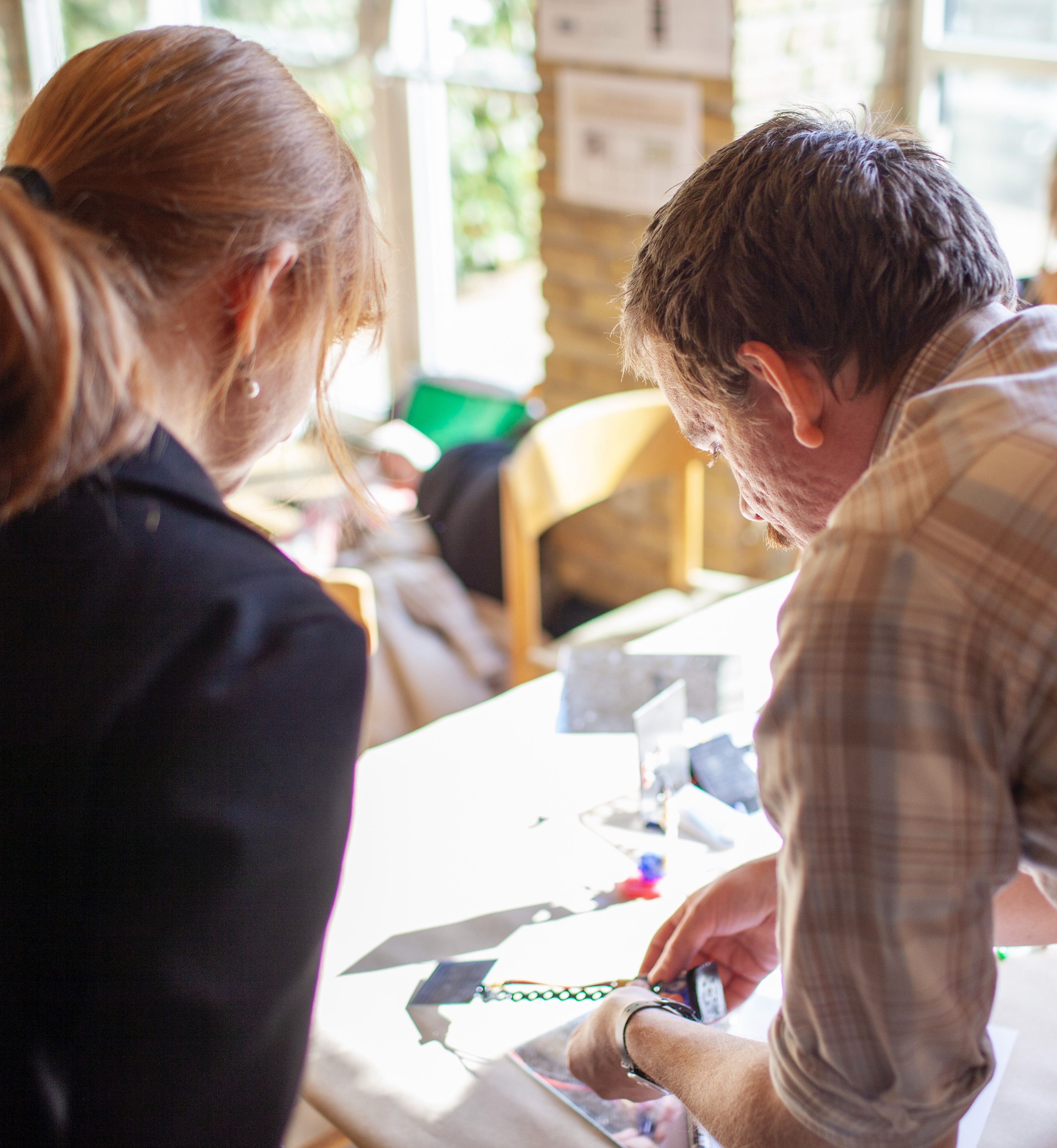 (Article Figure 3) A facilitator demonstrates how the construction materials work for a new participant.